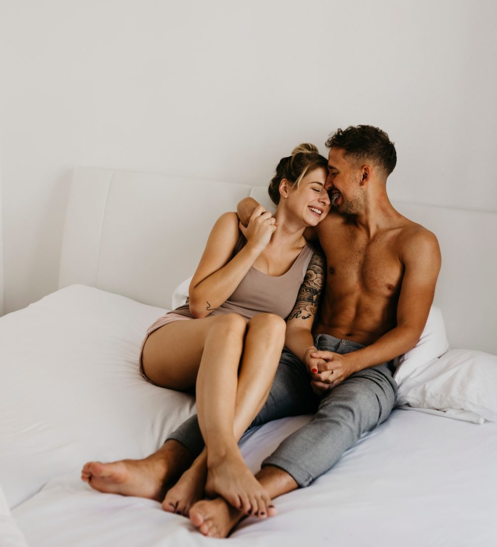 Happy young couple sitting in bed Happy young couple sitting in bed